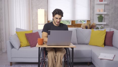 Disabled-teenager-in-wheelchair-working-with-laptop.
